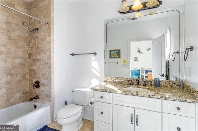 full bathroom featuring tiled shower / bath, vanity, and toilet