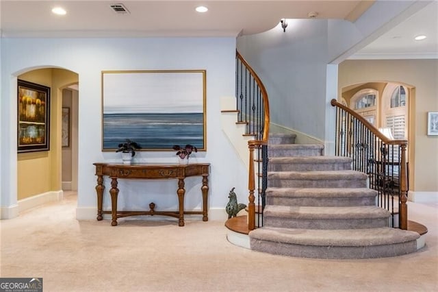 stairs featuring crown molding and carpet