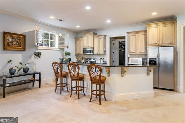 kitchen featuring a breakfast bar, crown molding, a center island, stainless steel appliances, and backsplash