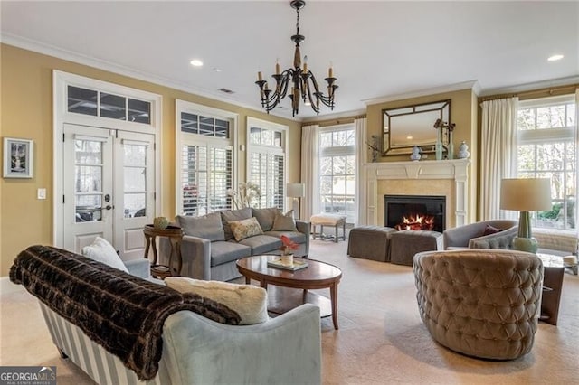 carpeted living room featuring french doors, ornamental molding, an inviting chandelier, and a wealth of natural light