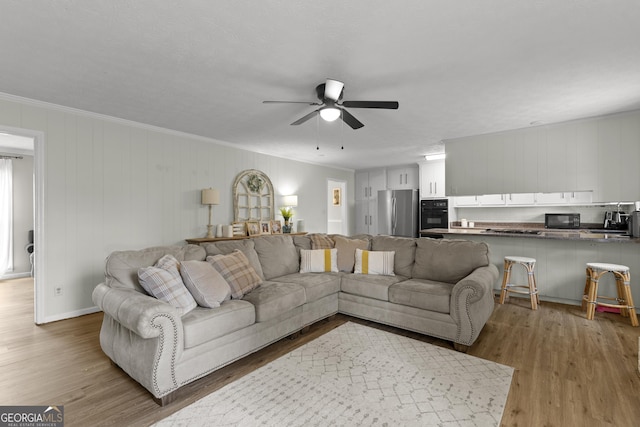 living room featuring ornamental molding, hardwood / wood-style floors, and ceiling fan