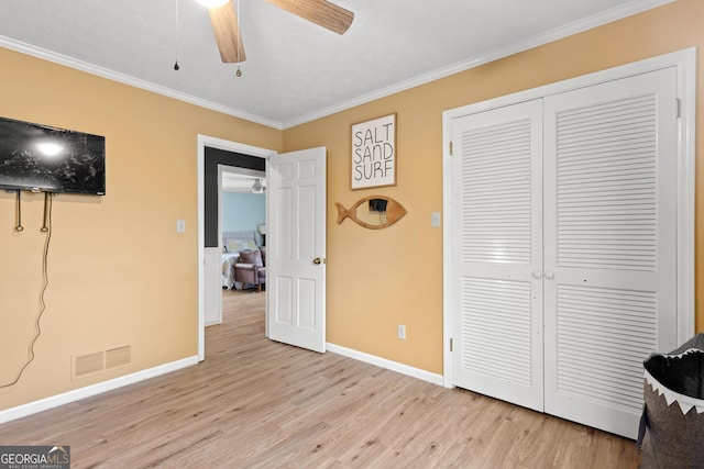 bedroom featuring ornamental molding, a closet, and light hardwood / wood-style flooring