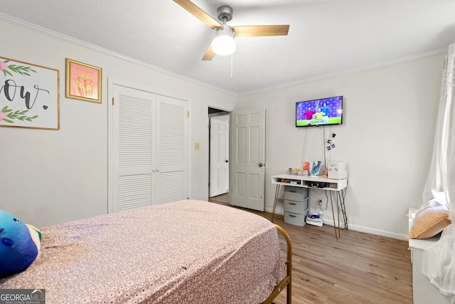 bedroom featuring crown molding, a closet, ceiling fan, and hardwood / wood-style flooring