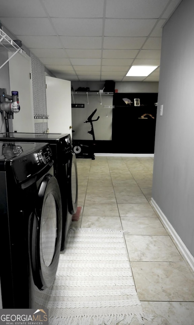 clothes washing area featuring washer and dryer and light tile patterned floors