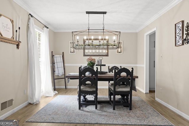 dining space with crown molding and wood-type flooring