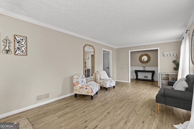 living room featuring crown molding and light hardwood / wood-style floors