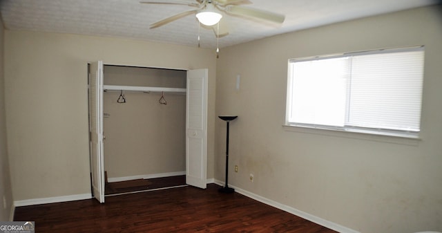 unfurnished bedroom with ceiling fan, dark hardwood / wood-style floors, and a closet