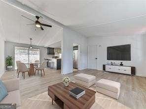 living room featuring lofted ceiling, hardwood / wood-style floors, and ceiling fan