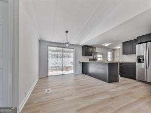 kitchen featuring plenty of natural light, light hardwood / wood-style floors, and stainless steel fridge with ice dispenser