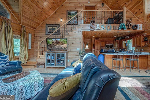 living room featuring sink, wood walls, wood ceiling, high vaulted ceiling, and light hardwood / wood-style floors