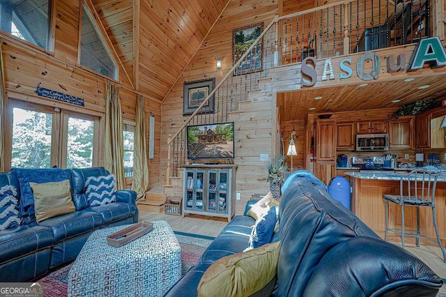 living room with high vaulted ceiling, light wood-type flooring, wood ceiling, and wooden walls