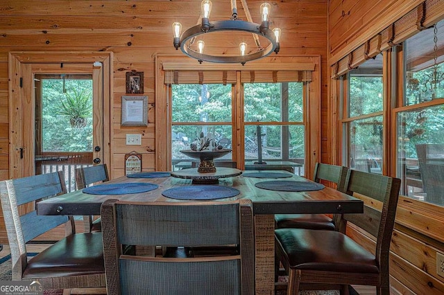 dining area featuring wooden walls and a chandelier