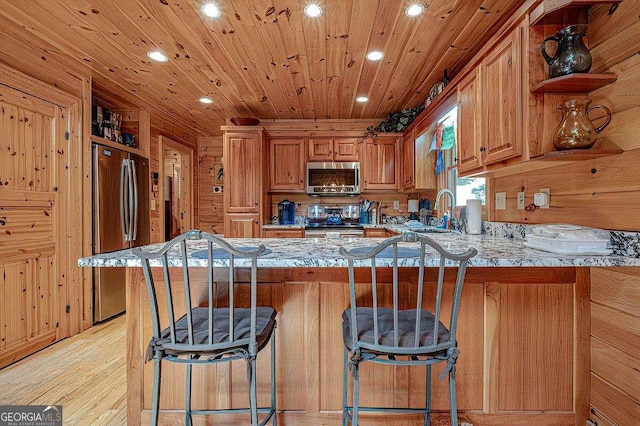 kitchen with sink, a breakfast bar area, stainless steel appliances, and kitchen peninsula