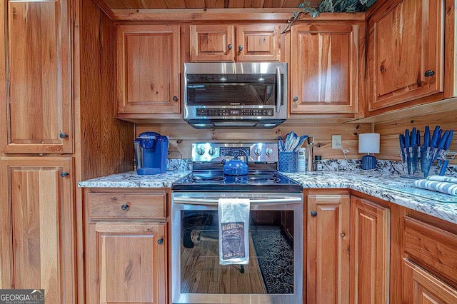 kitchen with stainless steel appliances and light stone counters