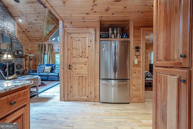 kitchen featuring wooden ceiling, stainless steel fridge, light stone countertops, and light wood-type flooring