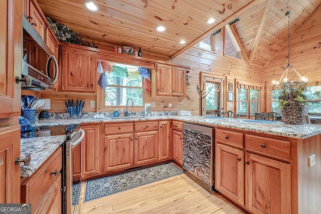 kitchen featuring sink, hanging light fixtures, appliances with stainless steel finishes, kitchen peninsula, and light stone countertops