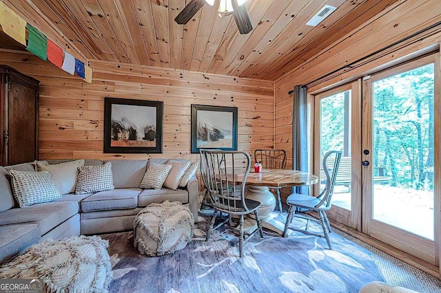 living room with wooden ceiling, french doors, ceiling fan, and wood walls