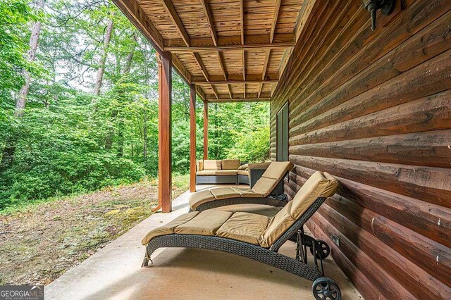 bedroom featuring vaulted ceiling, wood walls, wood ceiling, and light hardwood / wood-style flooring