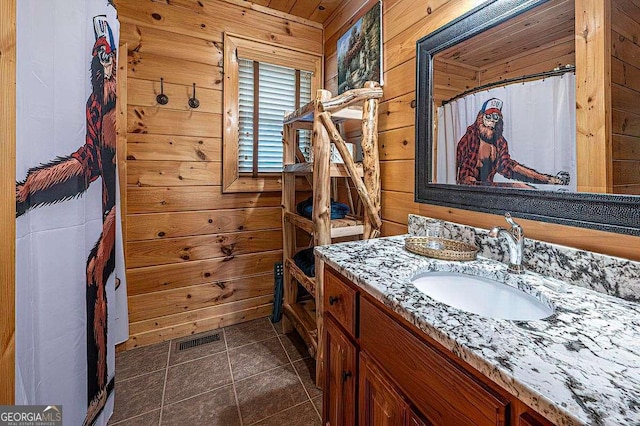 bathroom with tile patterned floors, vanity, wooden walls, and a shower with shower curtain