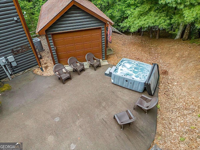 view of patio / terrace featuring a garage, an outdoor structure, and central air condition unit