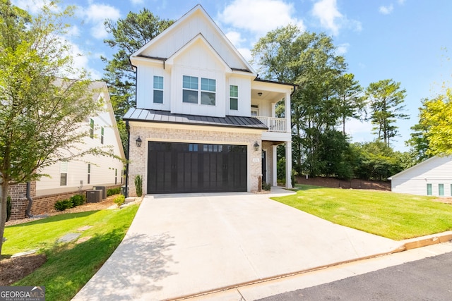 view of front of house featuring a garage, a front lawn, a balcony, and central air condition unit