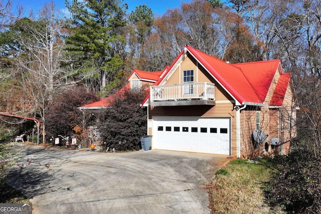 view of side of property with a garage and a balcony