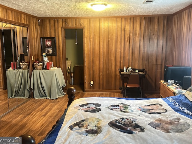 6100 White House Pkwy, Warm Springs, GA 31830 - bedroom featuring a textured ceiling, crown molding, wood walls, visible vents, and wood finished floors