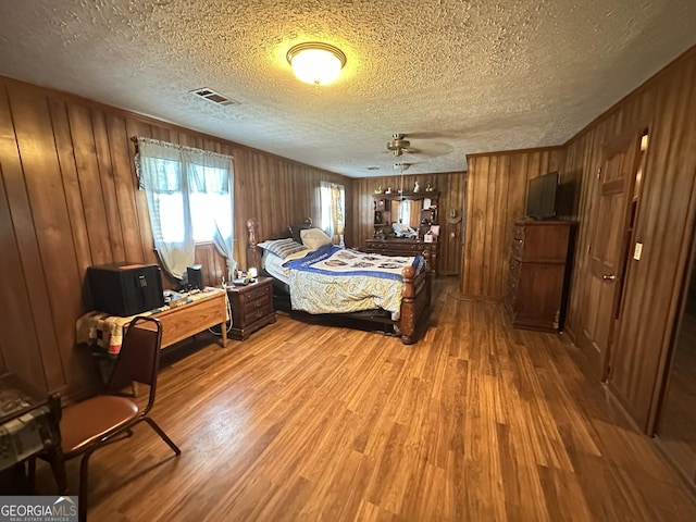 6100 White House Pkwy, Warm Springs, GA 31830 - bedroom with a textured ceiling, wood finished floors, wooden walls, and visible vents