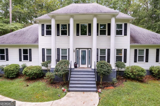 greek revival inspired property featuring a front lawn