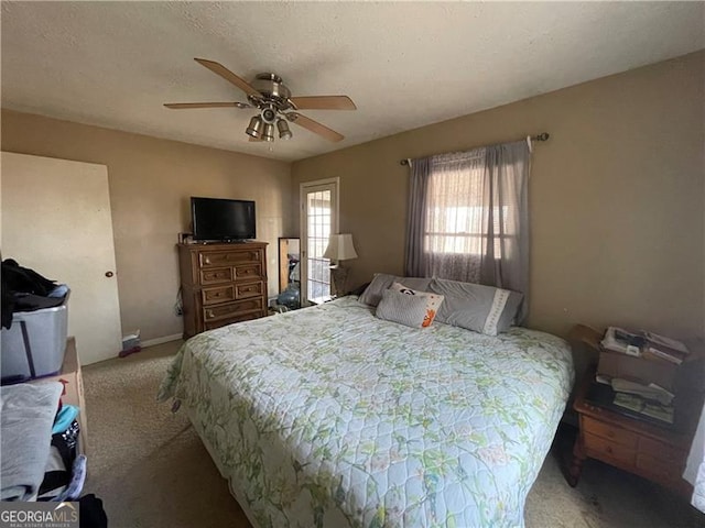 carpeted bedroom with ceiling fan and a textured ceiling