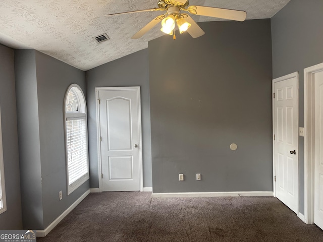 carpeted spare room with ceiling fan, lofted ceiling, and a textured ceiling