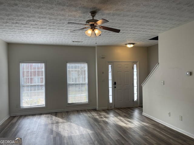 foyer with ceiling fan, dark wood-type flooring, and a textured ceiling