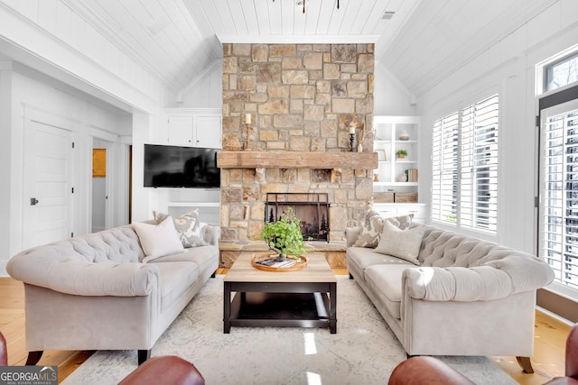 living room featuring wood ceiling, lofted ceiling, a stone fireplace, and built in features