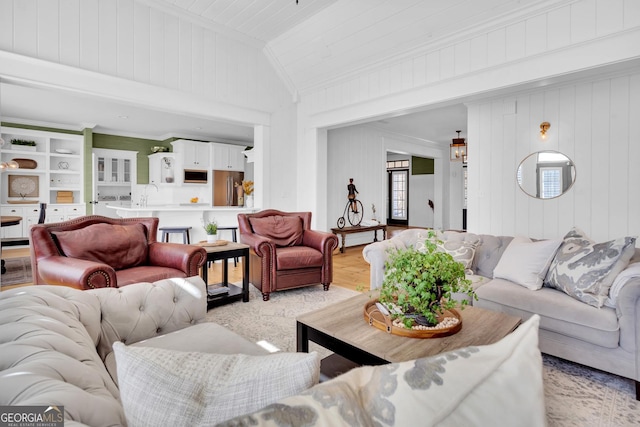 living room featuring sink, crown molding, vaulted ceiling, and light wood-type flooring