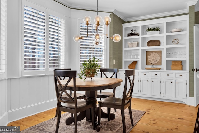 dining area with crown molding, a healthy amount of sunlight, and light wood-type flooring