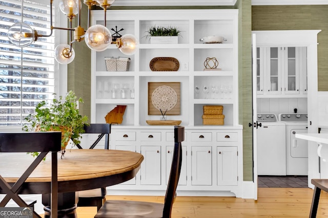 interior space featuring washing machine and clothes dryer and light hardwood / wood-style flooring