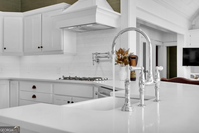 kitchen featuring premium range hood, white cabinetry, gas cooktop, and backsplash