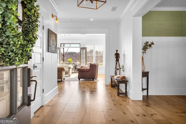 corridor featuring crown molding and light hardwood / wood-style floors