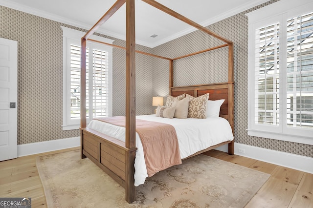 bedroom featuring ornamental molding and light wood-type flooring