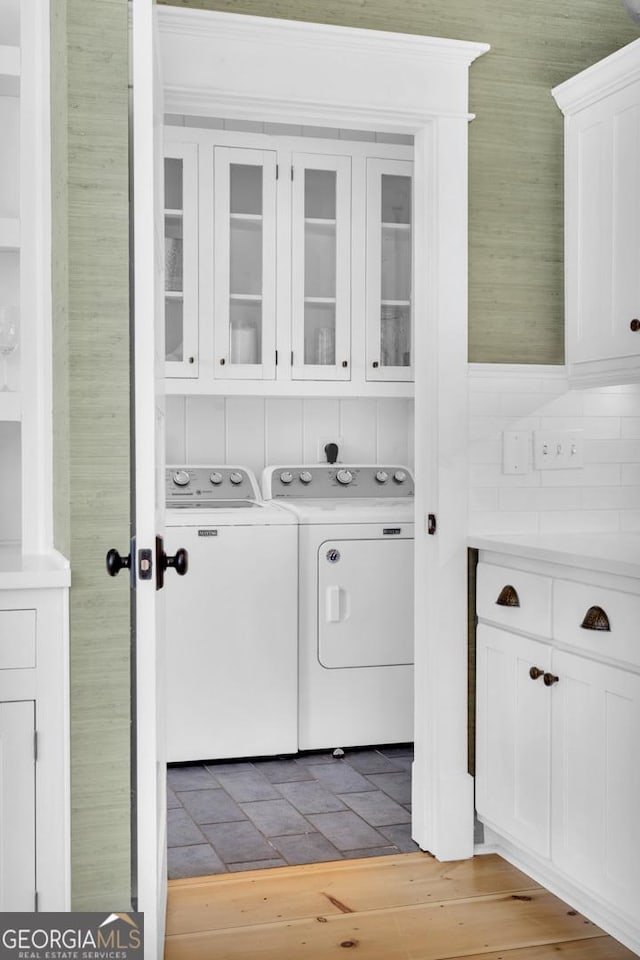 washroom featuring cabinets and washing machine and dryer