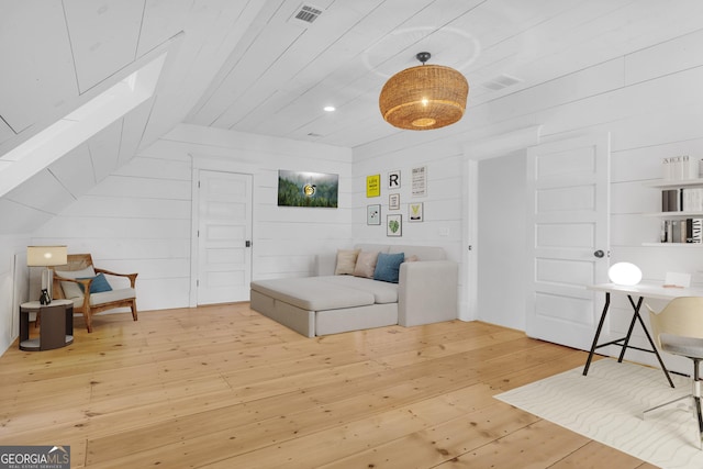 living area with hardwood / wood-style flooring and vaulted ceiling