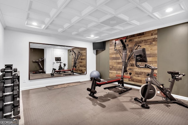 workout room featuring coffered ceiling and wooden walls