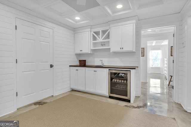 kitchen featuring white cabinets, coffered ceiling, sink, and beverage cooler