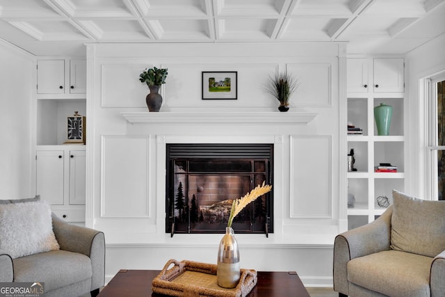 living room featuring beamed ceiling, coffered ceiling, and built in shelves