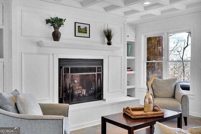 living room with beamed ceiling, coffered ceiling, hardwood / wood-style floors, and built in features