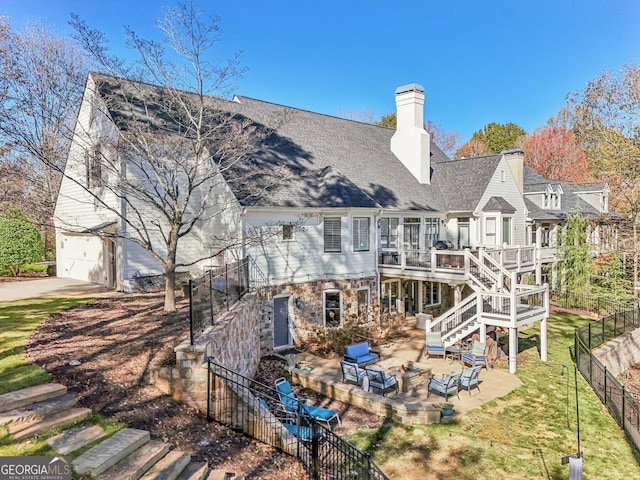 rear view of property with a lawn, a deck, and a patio area