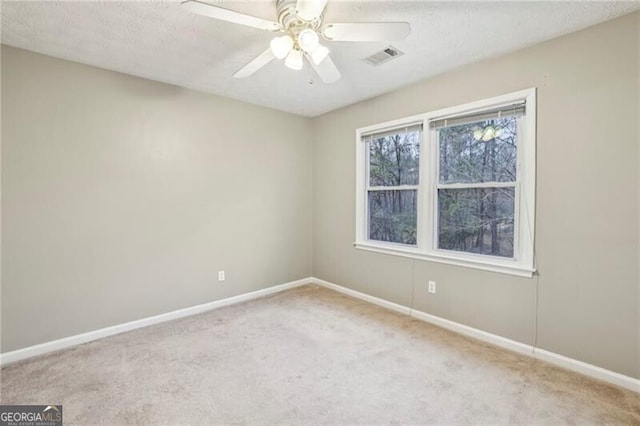 carpeted spare room featuring ceiling fan and a textured ceiling