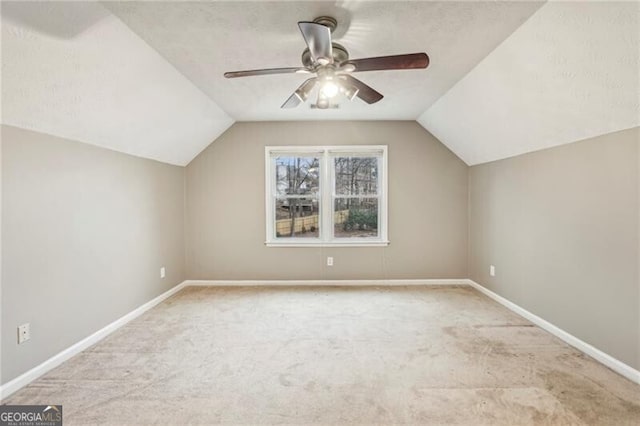 bonus room featuring lofted ceiling, a textured ceiling, light colored carpet, and ceiling fan