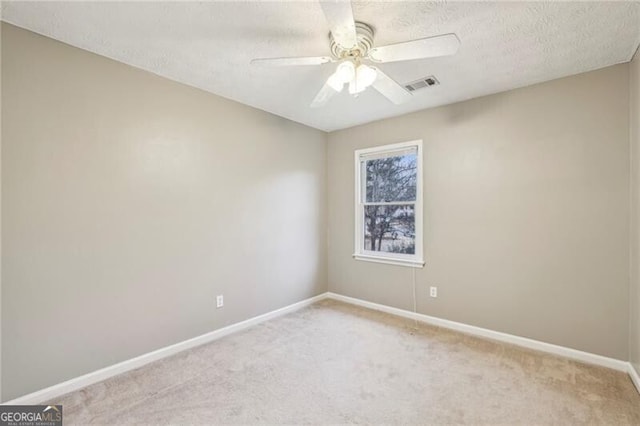 unfurnished room featuring ceiling fan, light carpet, and a textured ceiling