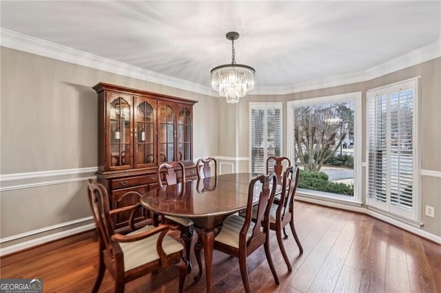 dining space with an inviting chandelier, dark hardwood / wood-style flooring, and crown molding